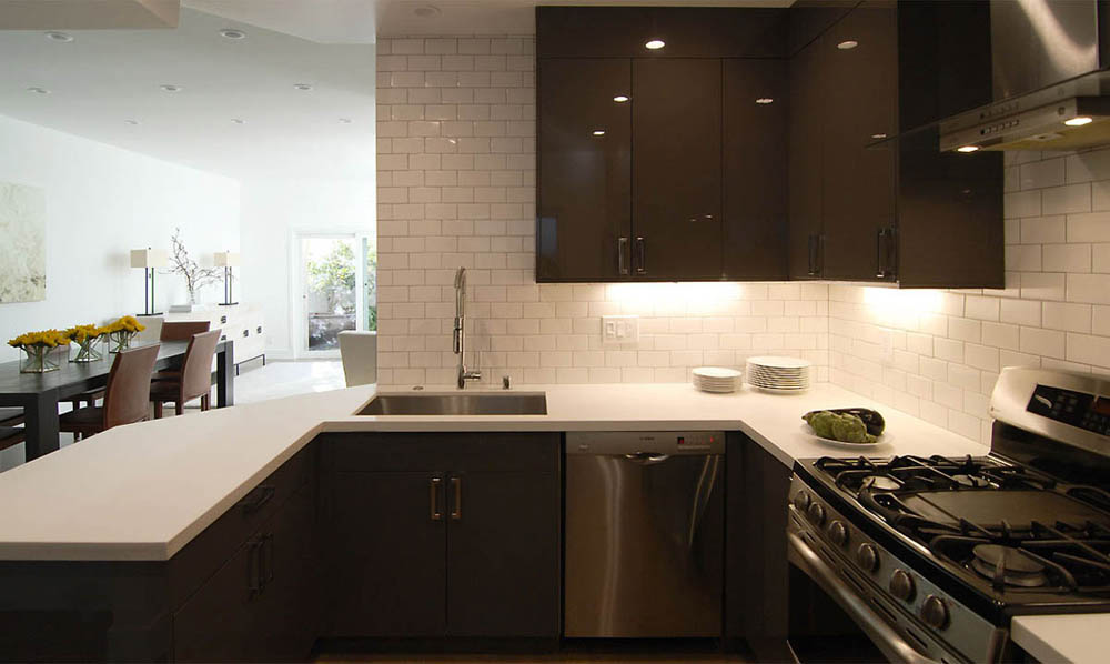 High gloss kitchen cabinets, stainless steel appliances and subway tile in the kitchen.