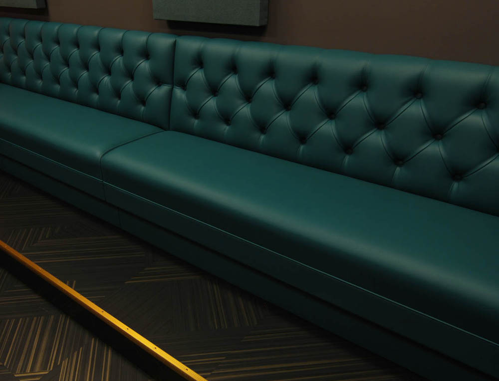 The space is a music studio and a classroom so the back wall seating was put on a slight riser so students could see better. Flooring is Emerge by Shaw Contract.